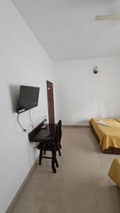 a room with a desk and a bed and a room with a computer at ThekkadyPknhomes in Thekkady