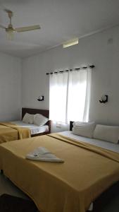 a room with two beds and a window at ThekkadyPknhomes in Thekkady