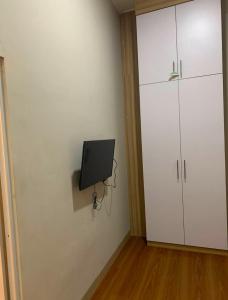 a room with a tv and a white cabinet at PH Residence Jakarta - Gajahmada in Jakarta