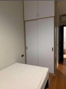 a bedroom with a white bed and a large closet at PH Residence Jakarta - Gajahmada in Jakarta