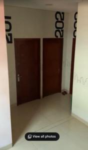 two brown doors in a room with a sign on the wall at PH Residence Jakarta - Gajahmada in Jakarta +3 photos