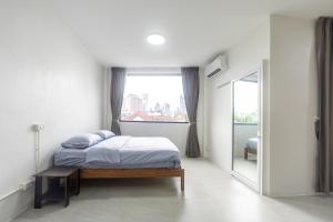 une chambre avec un lit et une grande fenêtre dans l'établissement WJ Luxury Sathorn, à Bangkok 50 autres photos