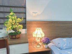 a lamp sitting on a table next to a plant at Trăng Khuyết 404MD in Hanoi