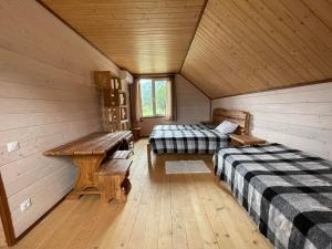 a room with two beds and a bench in a cabin at Панорама Маґура 2к in Tatariv
