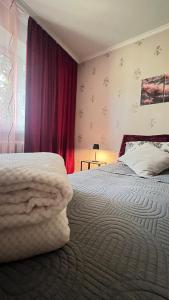 a bedroom with a bed and a red curtain at YSYS Apartments - your stylish housing in Rīga