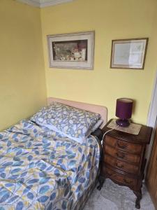 een slaapkamer met een bed en een dressoir met een lamp bij Single Sunny Stretford Room in Manchester