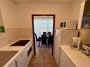 a kitchen with a white refrigerator and a table at Apartman Val in Dramalj
