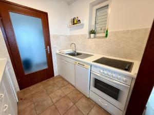 a kitchen with a sink and a stove at Apartman Val in Dramalj