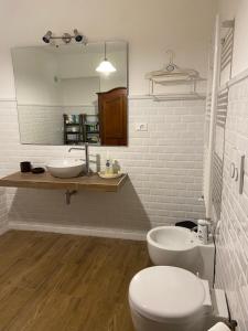 a bathroom with a toilet and a sink and a mirror at Villa Silvana Quiet Escape in Bolsena +35 photos