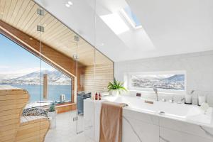 un bagno con una grande vasca e una grande finestra di Deluxe Villa by Paramount a Tromsø