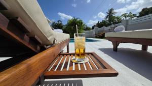 a glass of drink sitting on a table next to a pool at Villa in Sunset Crest, Holetown in Saint James