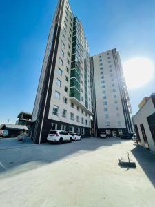 Un gran edificio con coches aparcados delante. en Sunrise Guesthouse UB, en Ulán Bator