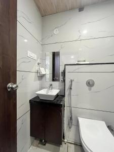 a white bathroom with a sink and a mirror at Jeel Pearl Hotel in Udaipur