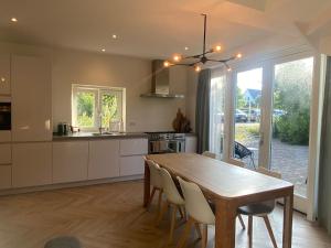 une cuisine et une salle à manger avec une table et des chaises en bois dans l'établissement Ons Huisje Achter, à Noordwijkerhout
