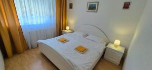 a small bedroom with a white bed and two lamps at Apartman Stanković in Teslić