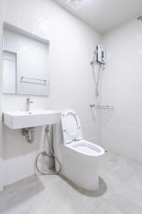 une salle de bains blanche avec toilettes et lavabo dans l'établissement WJ Luxury Sathorn, à Bangkok