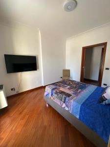 Un dormitorio con una cama y un televisor de pantalla plana. en Villa Oasi Bonita a Mondello, en Palermo