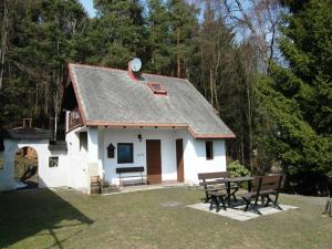 a small white house with a picnic table in front at Chalet in Malá Skála near Ski Slopes in Malá Skála