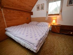 a bedroom with a bed in a room with a window at Chalet in Malá Skála near Ski Slopes in Malá Skála