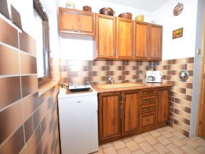 a small kitchen with wooden cabinets and a white refrigerator at Chalet in Malá Skála near Ski Slopes in Malá Skála +31 photos