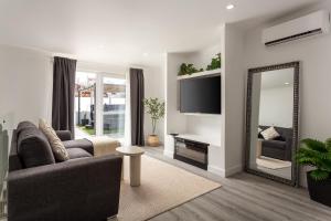 a living room with a couch and a mirror at Linda s Guest House Alojamento 2 in Costa da Caparica