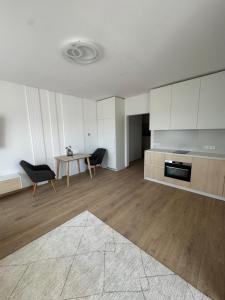 een grote woonkamer met een tafel en een keuken bij Danubia-residence in Komárno