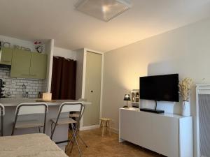 Una sala de estar con cocina y comedor. en Studio cosy avec terrasse & vue sur pistes, en Gérardmer