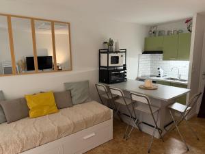 Una sala de estar con un sofá y una cocina. en Studio cosy avec terrasse & vue sur pistes, en Gérardmer