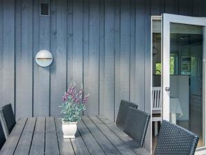 a wooden table with chairs and a vase with flowers at 6 person holiday home in Haderslev-By Traum in Diernæs