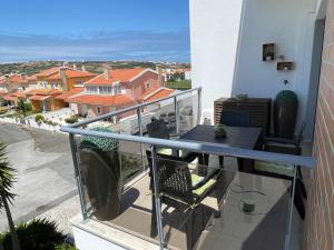 a balcony with a table and chairs on a building at Stylish & Spacious Apartment with Balcony in Lourinhã