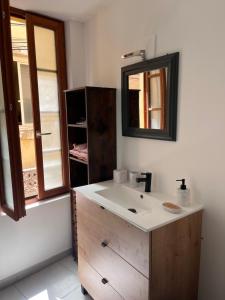 een badkamer met een wastafel en een spiegel bij Hyper centre de Narbonne in Narbonne