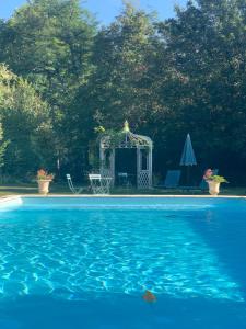 a blue swimming pool with a gazebo in a yard at French Manor House with private gardens and pool in Foissac