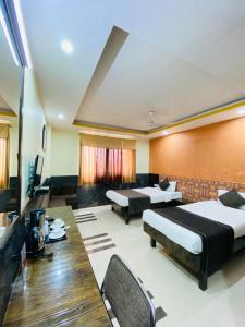 a room with two beds and a table and chairs at Nakshatra Hotel in Bānswāra