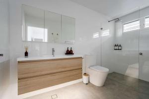 卡尔布拉海滩34° Degrees South Culburra的浴室里有马桶、洗手池和淋浴。 更多23张照片