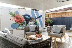 卡尔布拉海滩34° Degrees South Culburra的一个带桌椅和壁画的庭院