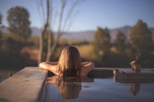 a woman in the water in a bath tub at Asher Riverside Cottages in Bonnievale +2 photos