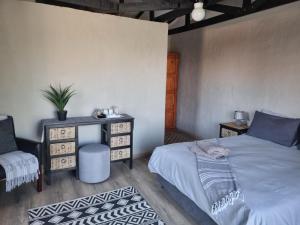 a bedroom with a bed and a table and a chair at Nyani Lodge Dinokeng in Pretoria +127 photos