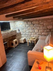 Una sala de estar con un sofá y una chimenea de piedra. en La Caseta, en Arbeca