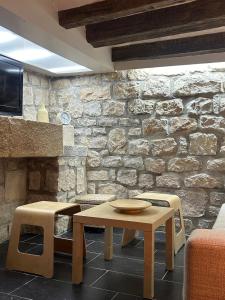 Una sala de estar con una mesa y una pared de piedra. en La Caseta, en Arbeca