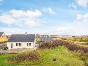 a white house with a black roof in a field at 6 person holiday home in Harboøre-By Traum in Harboør