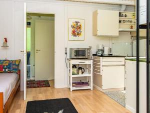 a room with a kitchen with a microwave and a stove at 5 person holiday home in Ry in Ry