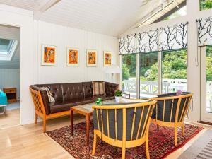 a living room with a couch and a table and chairs at 5 person holiday home in Ry in Ry