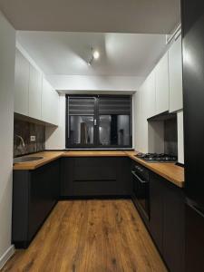 a kitchen with black and white cabinets and a window at Apartament Modern Urban Space - FREE Parking in Voluntari