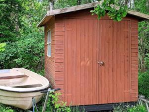 a small red shed with a boat next to it at Tranquil Lakeside Retreat in Ry-By Traum in Ry