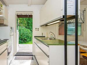 a kitchen with white cabinets and a sink at 5 person holiday home in Ry in Ry