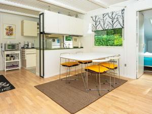 a kitchen with a table and chairs in a room at 5 person holiday home in Ry in Ry