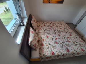 a small bedroom with a bed with a floral blanket at Natur Oase 2 in Goch
