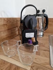 Una tetera y dos cuencos de cristal sobre un mostrador. en T3 Duplex - Centre-ville, en Saint-Pourçain-sur-Sioule