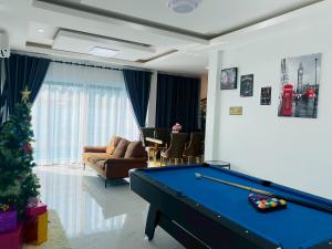 a living room with a pool table and a christmas tree at Cher Cher Pool Villa in Ban Chang