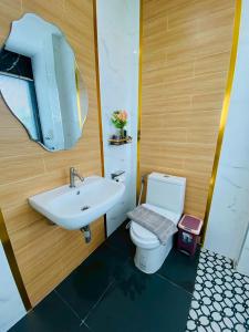 a bathroom with a sink and a toilet and a mirror at Cher Cher Pool Villa in Ban Chang